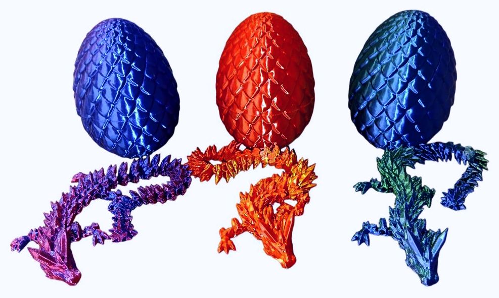 Three dragon-shaped sculptures with egg-like bodies in blue, red, and green.