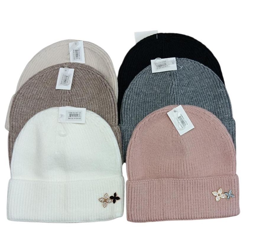 A set of six knit beanies in various colors with small tags and flower embellishments.